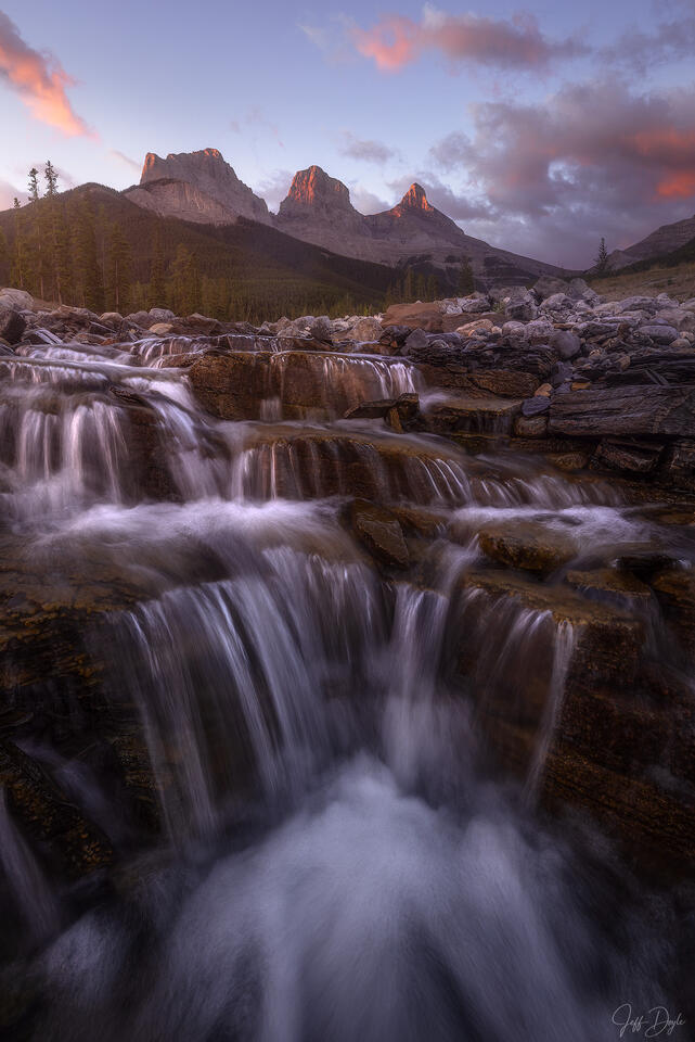 Cascading Waterfall Beneath Three Sisters Peaks at Sunrise