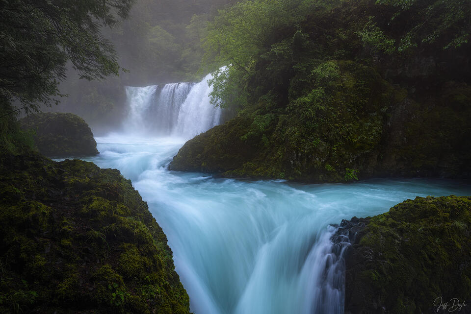 Spirit Falls with Misty Blue Waters and Mossy Riverbanks in Deep Gorge