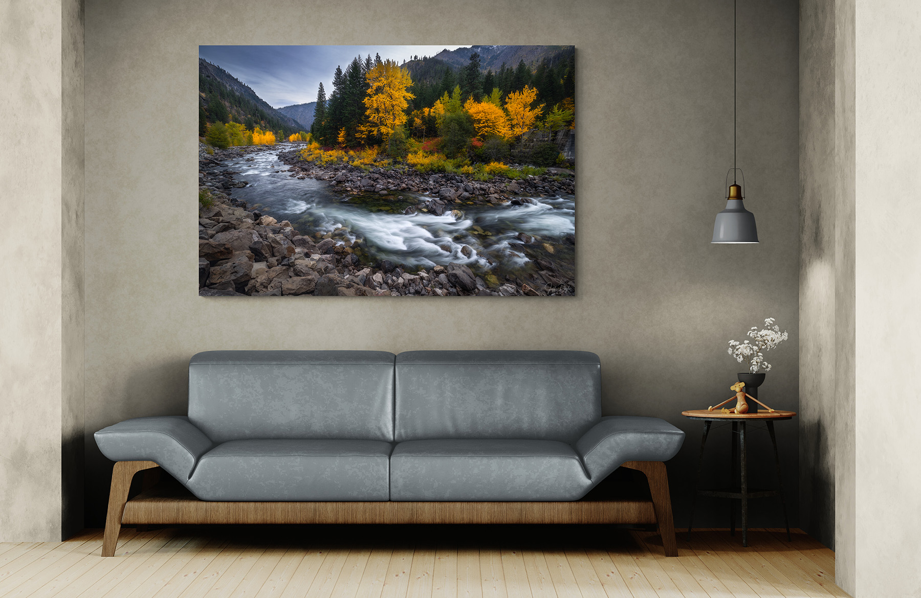 Fine art landscape photograph of a Pacific Northwest mountain river displayed above a gray sofa in a modern living room – showing how neutral wall colors complement landscape photography